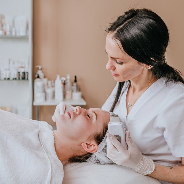 Esthetician making facial cleansing procedure